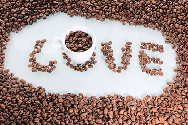 Coffee beans, love of coffee. Background with text love .Coffee white cup on the table. Hot drink in a white bowl. - Photo, Image