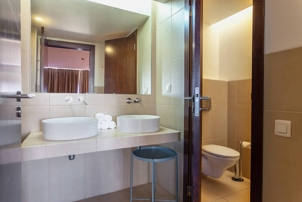 Modernes Badezimmer mit Badewanne, Spiegel und Waschbecken. Europäisches Hoteldesign. - Foto, Bild
