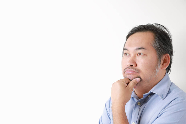Porträt asiatische Mann kaukasischen Bart trägt Hemd blau. Nachdenken über Dinge vor weißem Hintergrund. - Foto, Bild