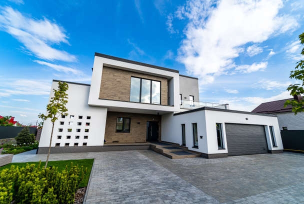 Modern luxury house with garage. Blue sky above. Nobody in the yard. Modern arhitecture. - Zdjęcie, obraz