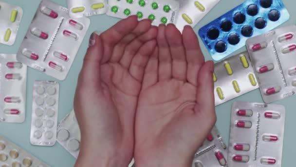 Vrouwelijke artsen handen vangen pillen met veel blaren op de achtergrond - Video
