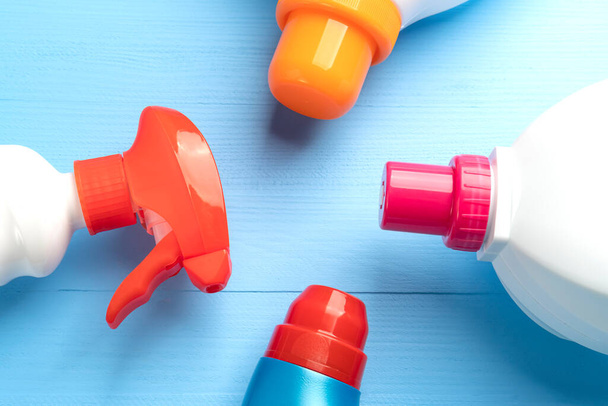 Bright multi-colored detergents in plastic bottles, liquid and spray, on a light blue wooden background. Copispace: The concept of disinfection and hygiene during a coronavirus pandemic - Фото, зображення