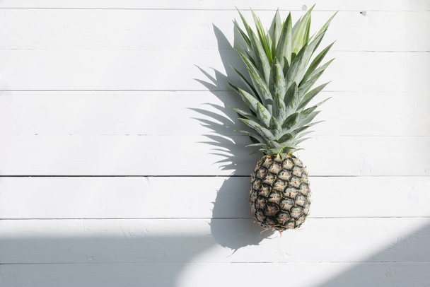 Pineapple on white wood background. Top view. - Фото, зображення