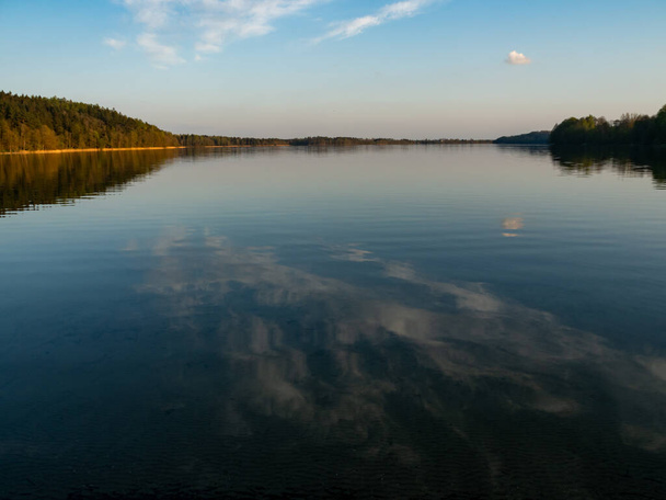Озеро Ханча, самое глубокое озеро Польши. Солнечный день, поздний вечер, небо отражается в воде. Сувальский ландшафтный парк, Подляское, Польша
 - Фото, изображение