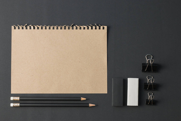 Office stationery, Blank note paper with clip paper, eraser, pencil on black desk flat lay. Top view have copy space. - Фото, изображение