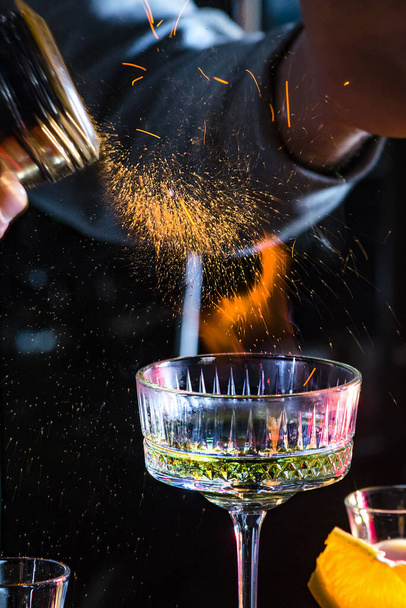 Extream vystřelil koktejl. Barman přidržuje cukr nad lahodným alkoholovým koktejlem. Proces výroby hořícího koktejlu - Fotografie, Obrázek