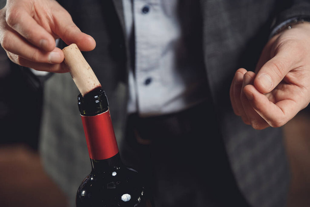 Sommelier ember szagolgatja parafa vörösbor palack dugóhúzó - Fotó, kép