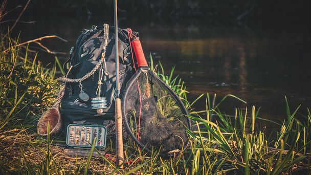 Canne à pêche, sac à dos et engins de pêche sur la rive de la rivière. Tenkara
. - Photo, image