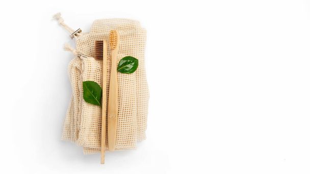 Bambu hammasharjat ja puuvilla laukku valkoisella pohjalla kopioi tilaa. Sosiaalinen ympäristövastuu. Ympäristöystävällinen konsepti, nolla jätettä, kierrätys, eko. Eristetty
. - Valokuva, kuva
