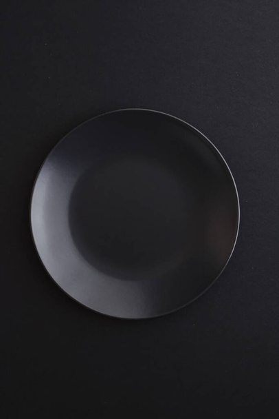 Empty plates on black background, premium dishware for holiday dinner, minimalistic design and diet - Foto, Imagem