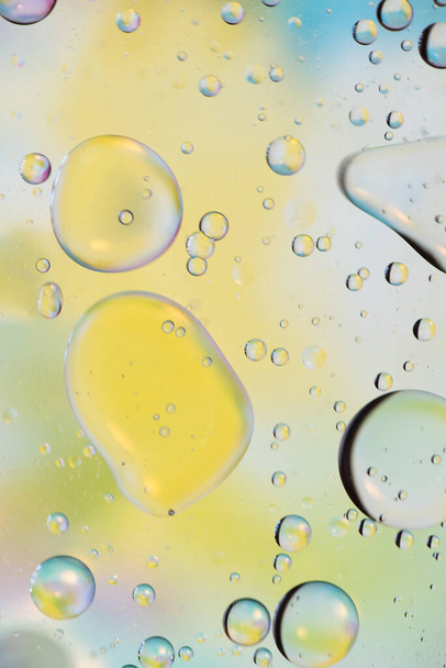Oil drops in water. Defocused abstract psychedelic pattern image green, yellow and white gradient colored. DOF. - Фото, изображение