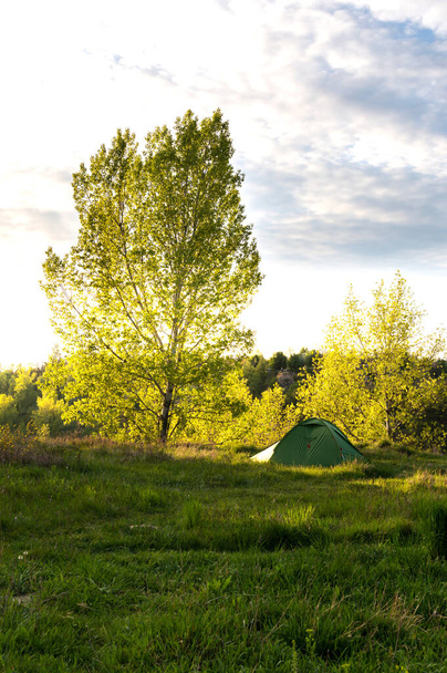 Solo hiking with a tent. Tourist tent under the tree. - Photo, Image