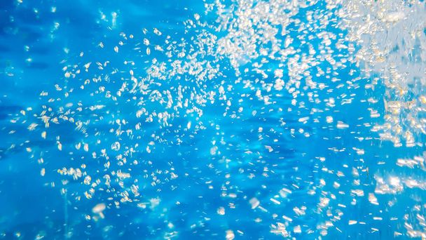 Sauerstoffblasen aus Wasser in der Tiefe. Natürlicher flüssiger blauer Hintergrund. - Foto, Bild