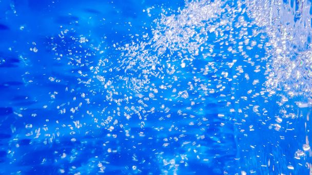 Кислородные пузырьки воды на глубине. Жидкий синий фон. - Фото, изображение