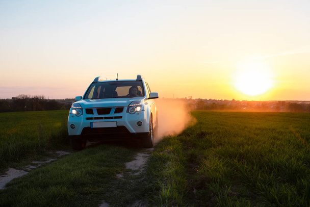 auto suv bianco a field road al tramonto. copia spazio
 - Foto, immagini