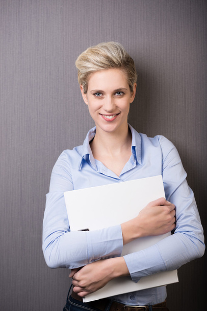 Confident young office worker clutching a file - Photo, Image