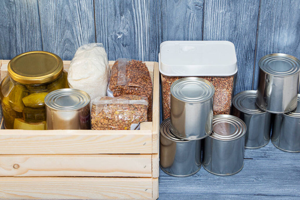 κονσερβοποιημένα τρόφιμα και διάφορα δημητριακά σε ξύλινο ράφι, διατροφική κρίση - Φωτογραφία, εικόνα
