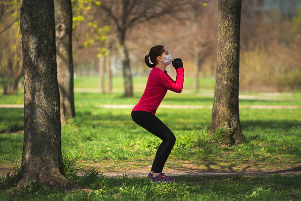 młoda dziewczyna idzie do sportu w parku w masce medycznej i rękawiczki po kwarantannie - Zdjęcie, obraz