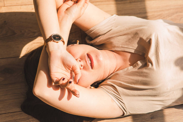 woman laying on floor. harsh sunlight. stay home - Foto, afbeelding