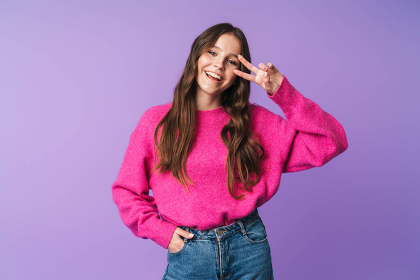 Image of young beautiful woman with long brown hair smiling and gesturing peace fingers isolated over violet background - Φωτογραφία, εικόνα