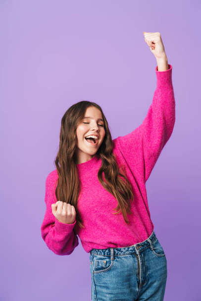 Image of young beautiful woman with long brown hair smiling and rejoicing as winner isolated over violet background - Φωτογραφία, εικόνα