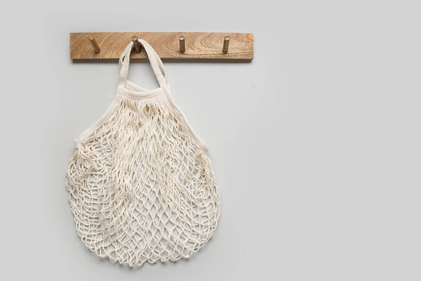 Empty cotton shopping eco bag hang on hanger on wall. Ready for shopping. Copy space. Zero waste concept. - 写真・画像
