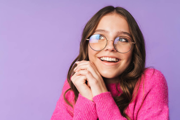 Image of young beautiful woman wearing eyeglasses smiling and looking upward isolated over violet background - Zdjęcie, obraz