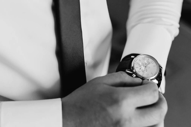 Empresario comprobando el tiempo en su reloj de pulsera
 - Foto, Imagen