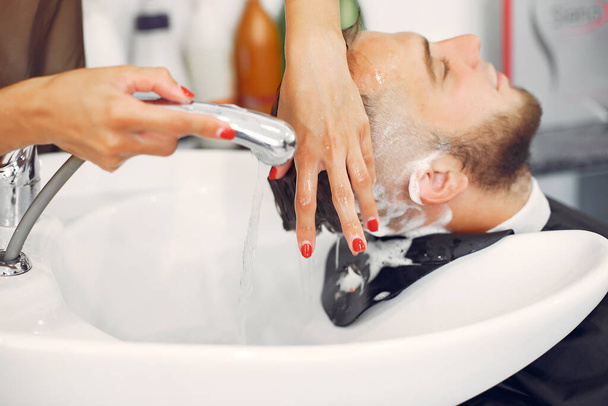 Woma washing mans head in a barbershop - Fotoğraf, Görsel