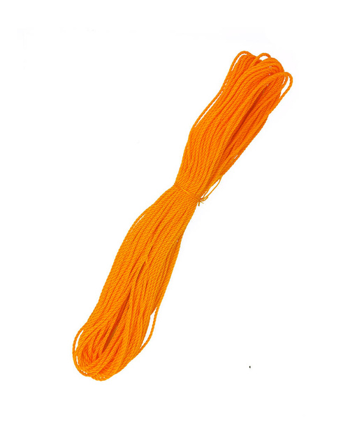 Nueva cuerda de nylon naranja aislada sobre fondo blanco sin sombra. Una bobina de cuerda naranja en primer plano
 - Foto, imagen