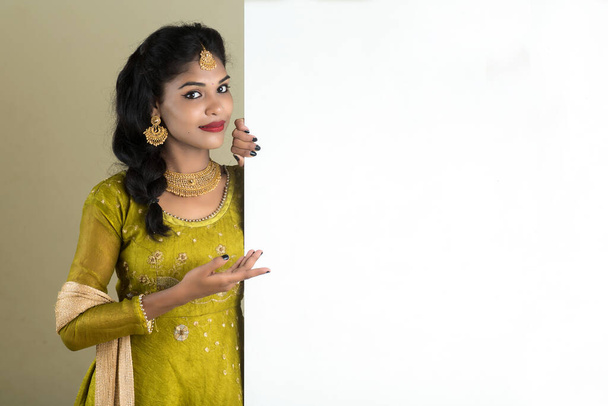 Traditional Girl holding and showing blank white sign board - Foto, afbeelding