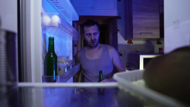 Unemployed looking for food in the refrigerator. Leftovers. Lack of money due to the financial crisis. A fired man suffers from depression and insomnia. A crisis. Alcoholism due to unemployment. - Footage, Video