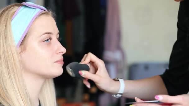 Makeup artist applies foundation cream on the face. Shooting takes place at home. Testing cosmetics at home. Video - Footage, Video