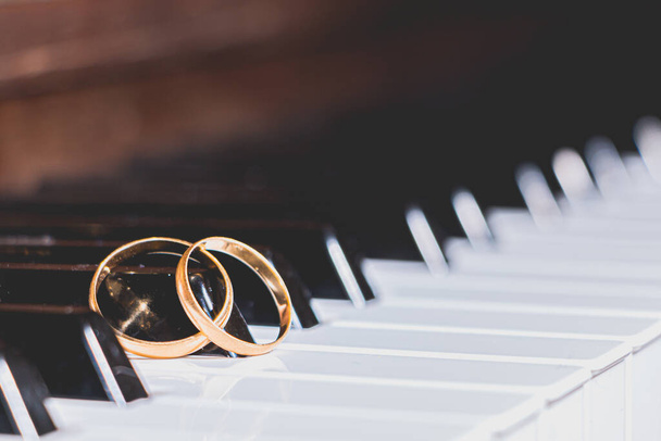 zlaté snubní prsteny na klavírním klíči - Fotografie, Obrázek