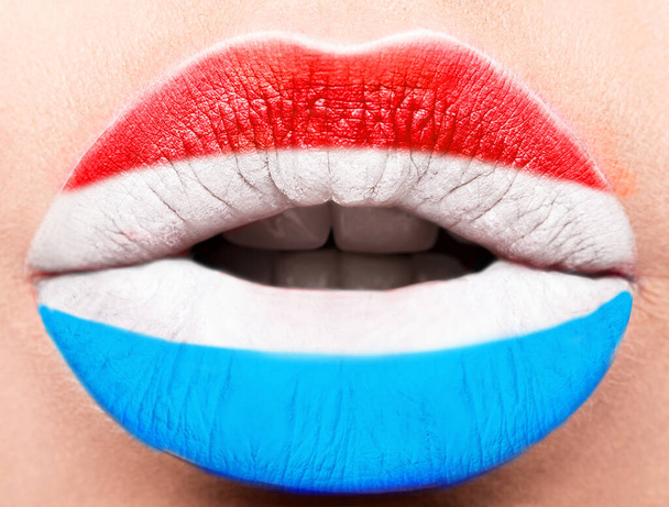 Female lips close up with a picture flag of Luxembourg. Blue, white, red - Φωτογραφία, εικόνα