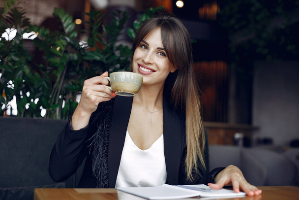 Geschäftsfrau sitzt am Tisch in einem Café und arbeitet - Foto, Bild
