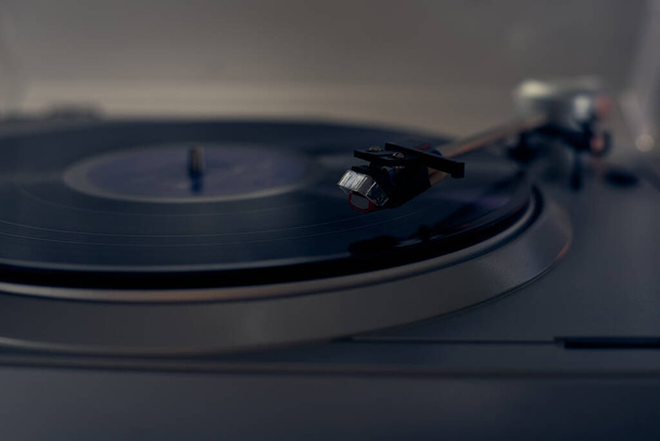 The vinyl needle reads the music from the record on a vinyl player. Old school. musical atmosphere. Old player and analog music. subject photo. - Photo, Image