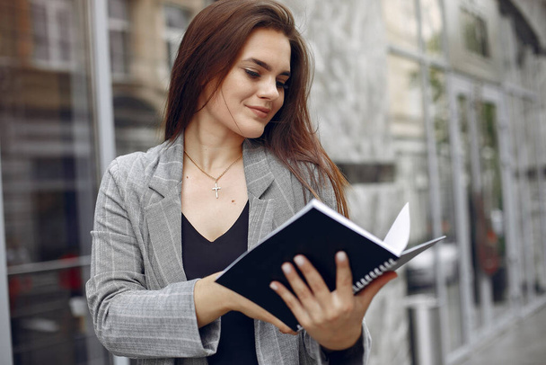 Elegant businesswoman working in a city and use the notebook - Фото, изображение