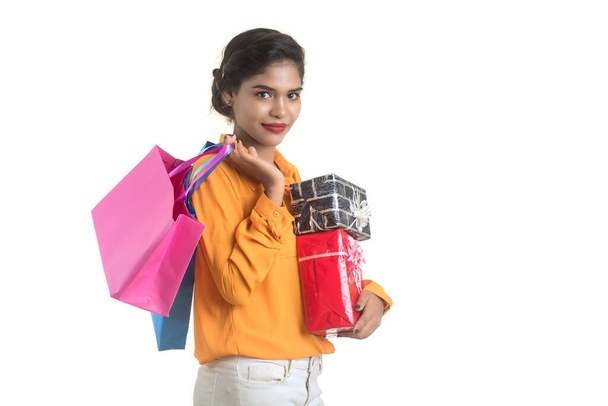 Beautiful woman carrying many shopping bags and gift Box on a white background. - Foto, afbeelding