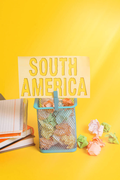 Writing note showing South America. Business photo showcasing Continent in Western Hemisphere Latinos known for Carnivals Trash bin crumpled paper clothespin office supplies yellow. - Photo, Image