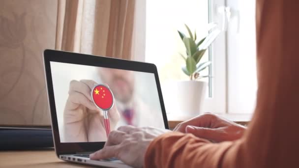 Physicians video call on the laptop at home, stethoscope bell with the Chinese flag. Telemedicine in China - Footage, Video