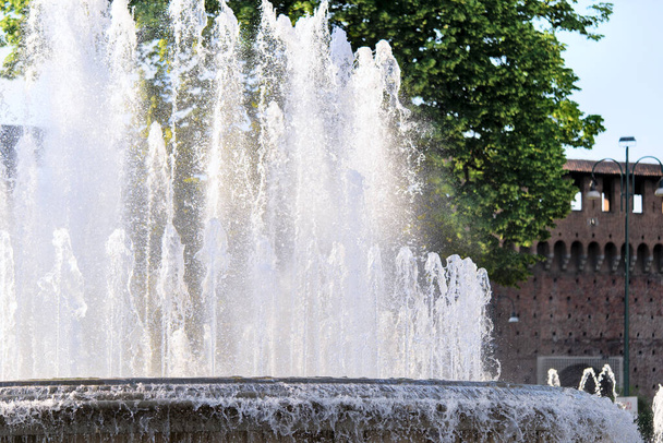 Fountain In front of the entrance to castle known as Castello Sforzesco, Milan, Lombardy, Italy. Closeup view - Photo, Image