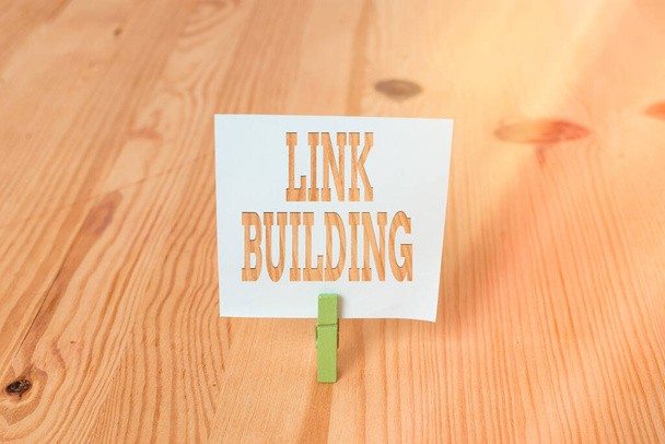 Handwriting text Link Building. Concept meaning SEO Term Exchange Links Acquire Hyperlinks Indexed Empty reminder wooden floor background green clothespin groove slot office. - Photo, Image