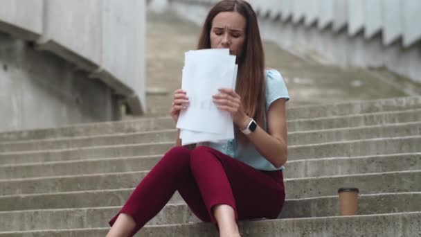 Businesswoman sitting on stairs with papers. Professional meditating on street - Footage, Video