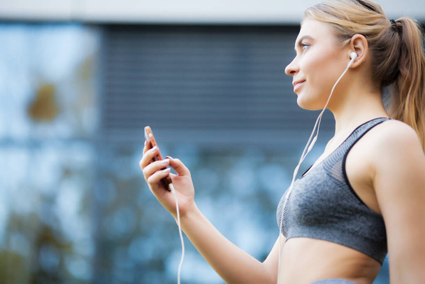 Jolie femme faisant du fitness à l'extérieur écoutant de la musique
 - Photo, image