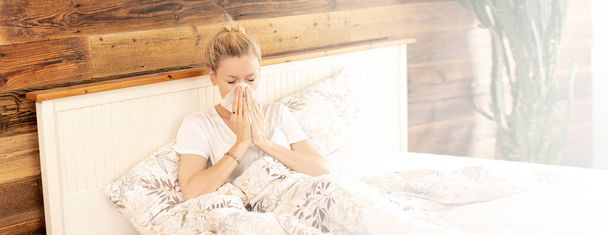 Caucasian adult woman lying in bed with flu, cold and fever. Sick girl . Quarantine time. - Photo, image