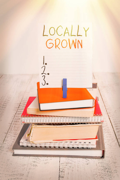 Word writing text Locally Grown. Business concept for Produced Agricultural Countryside Fresh Vegetables pile stacked books notebook pin clothespin colored reminder white wooden. - Photo, Image