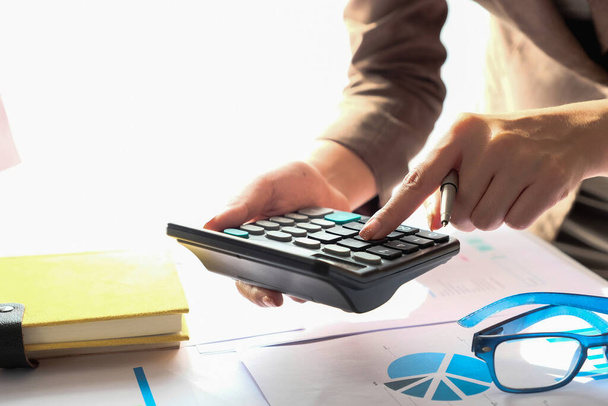 Zbliżenie Księgowy przy użyciu kalkulatora do obliczania kosztów finansowych w biurze domu - Zdjęcie, obraz