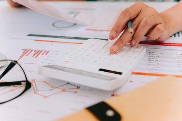 I revisori contabili utilizzano l'analisi della calcolatrice finanziaria dalle relazioni di bilancio - Foto, immagini