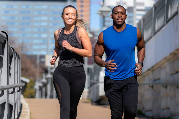 Grupo de gênero misto correndo ao ar livre na cidade urbana, homem e mulher casal, exercitando fitness no dia ensolarado
 - Foto, Imagem